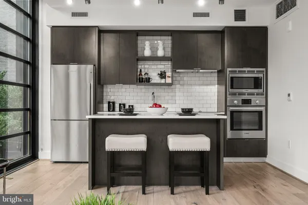 a kitchen with stainless steel appliances granite countertop a refrigerator and a stove