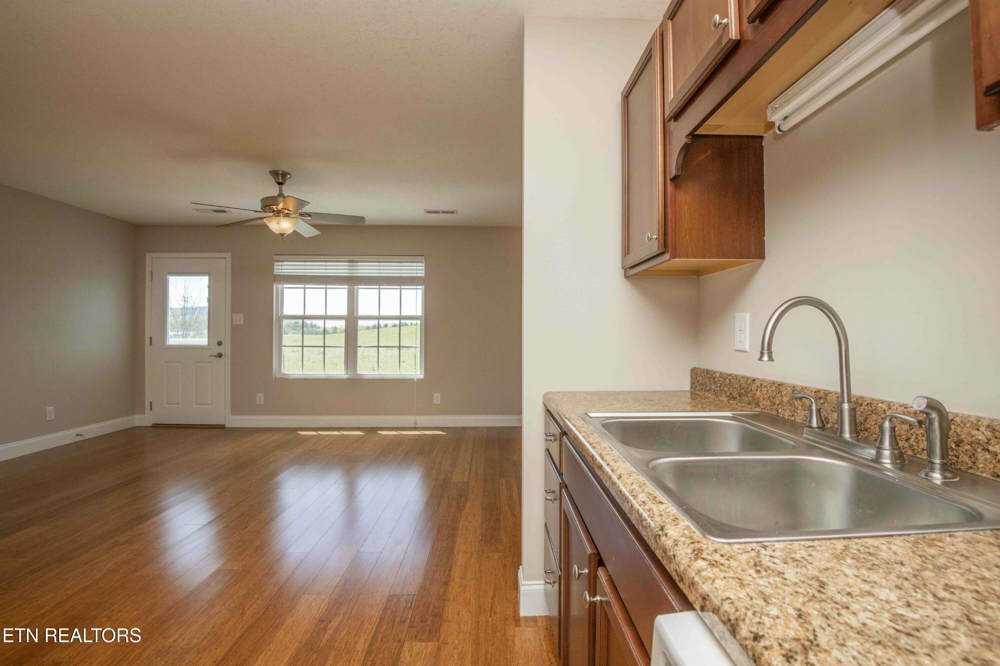337 Angus Crossing Corryton, TN 37721 - Photo 9 of 36 a kitchen with kitchen island a sink wooden floor and a large window