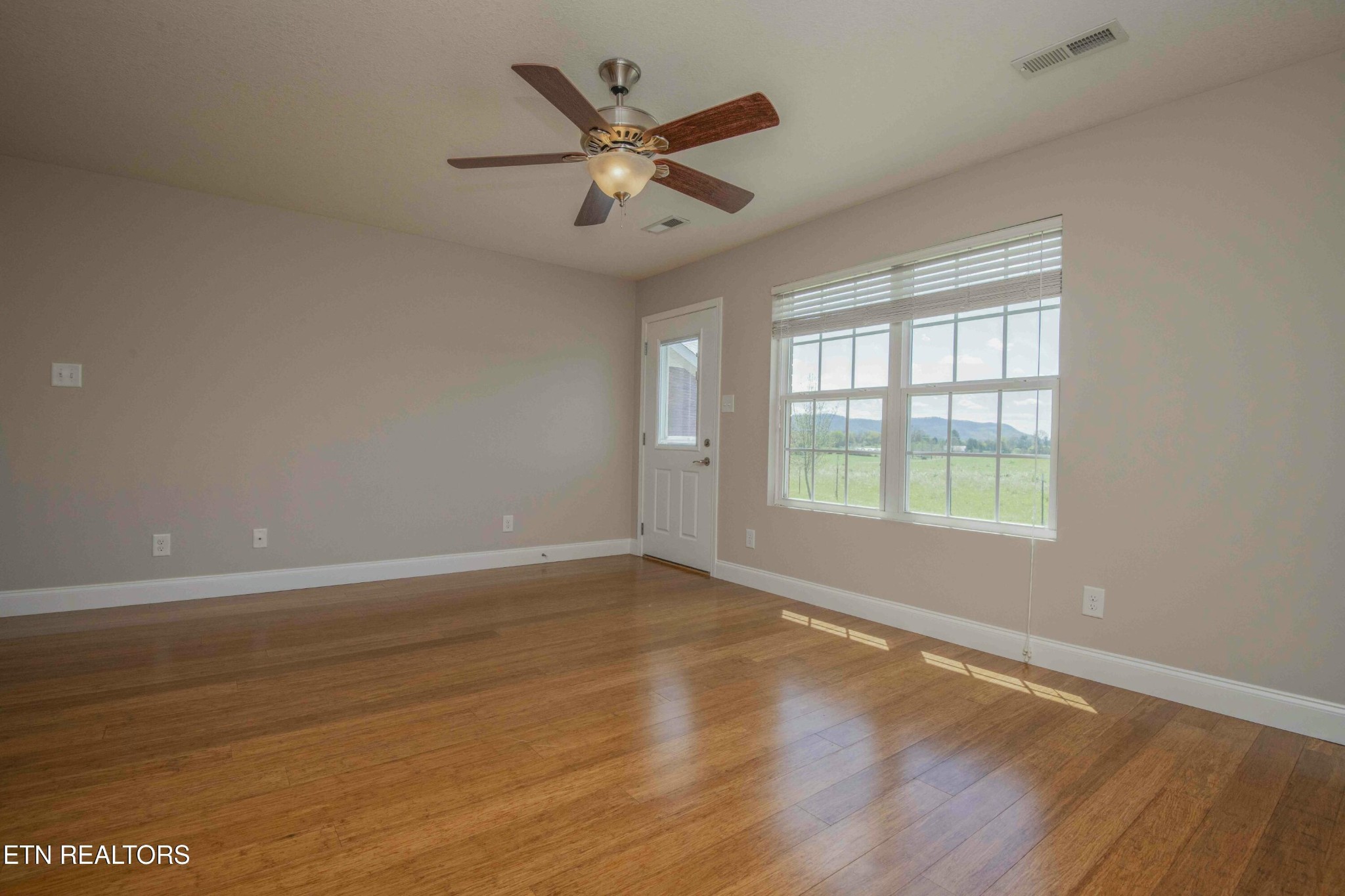337 Angus Crossing Corryton, TN 37721 - Photo 10 of 36 an empty room with wooden floor and windows