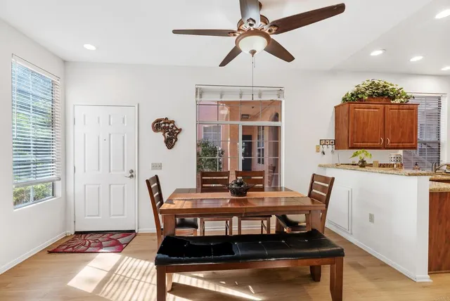 a kitchen with stainless steel appliances granite countertop a refrigerator a sink dishwasher and wooden cabinets with wooden floor