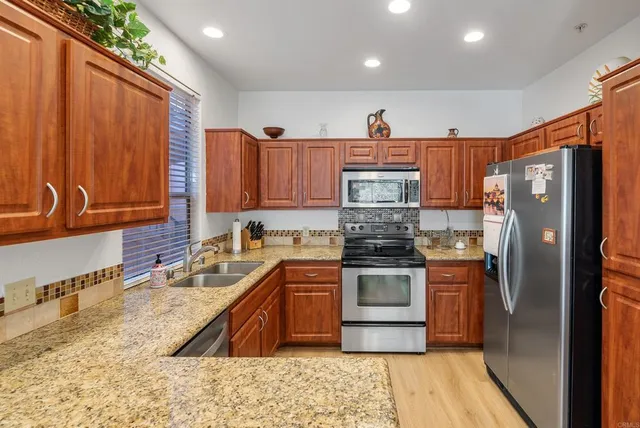 a kitchen with stainless steel appliances granite countertop a refrigerator sink and cabinets