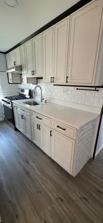 a kitchen with granite countertop white cabinets and white appliances