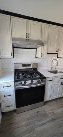 a kitchen with granite countertop a stove and a sink