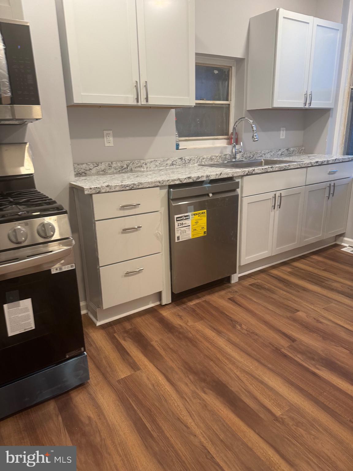 2732 Riggs Avenue Baltimore, MD 21216 - Photo 13 of 23 a kitchen with granite countertop a stove a sink and a microwave