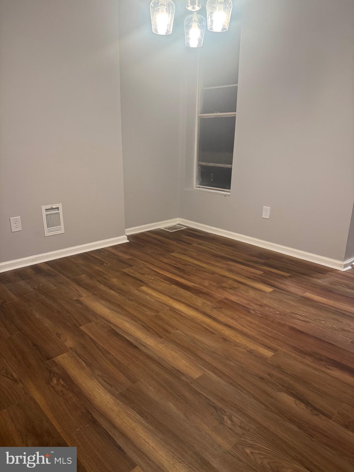2732 Riggs Avenue Baltimore, MD 21216 - Photo 7 of 23 a view of an empty room with wooden floor and a window