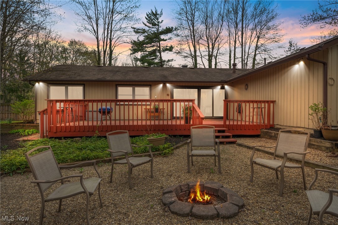 17800 Falling Leaves Road Strongsville, OH 44136 - Photo 30 of 39 Back of property at dusk featuring a patio, a shingled roof, a fire pit, and a deck