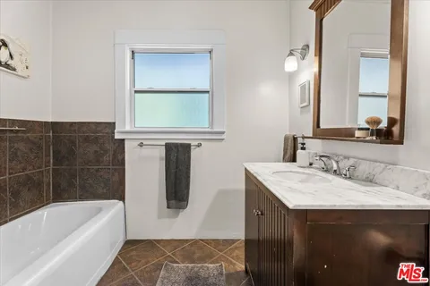 a bathroom with a tub sink and mirror
