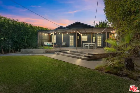 a front view of a house with swimming pool having outdoor seating