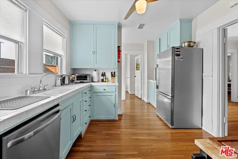 a kitchen with stainless steel appliances a refrigerator sink and cabinets