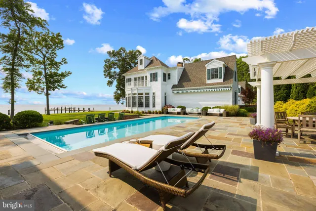 a view of a house with a big yard and large trees