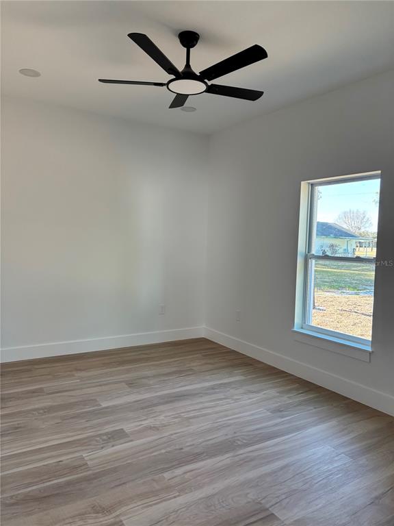 317 Quail Avenue Sebring, FL 33870 - Photo 14 of 19 wooden floor in an empty room with a window