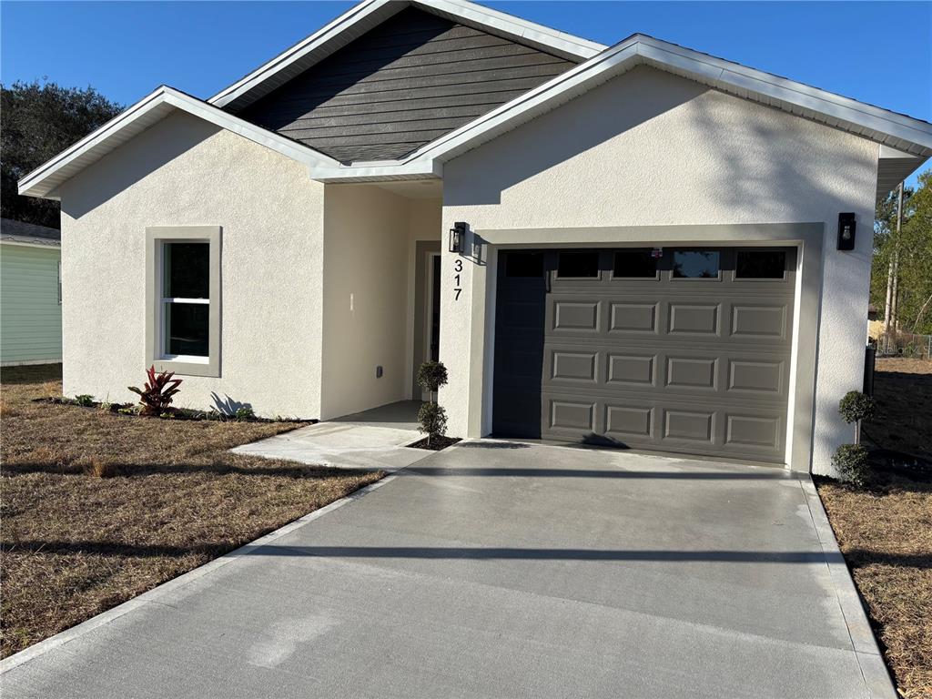 317 Quail Avenue Sebring, FL 33870 - Photo 2 of 19 a front view of a house with a yard and garage