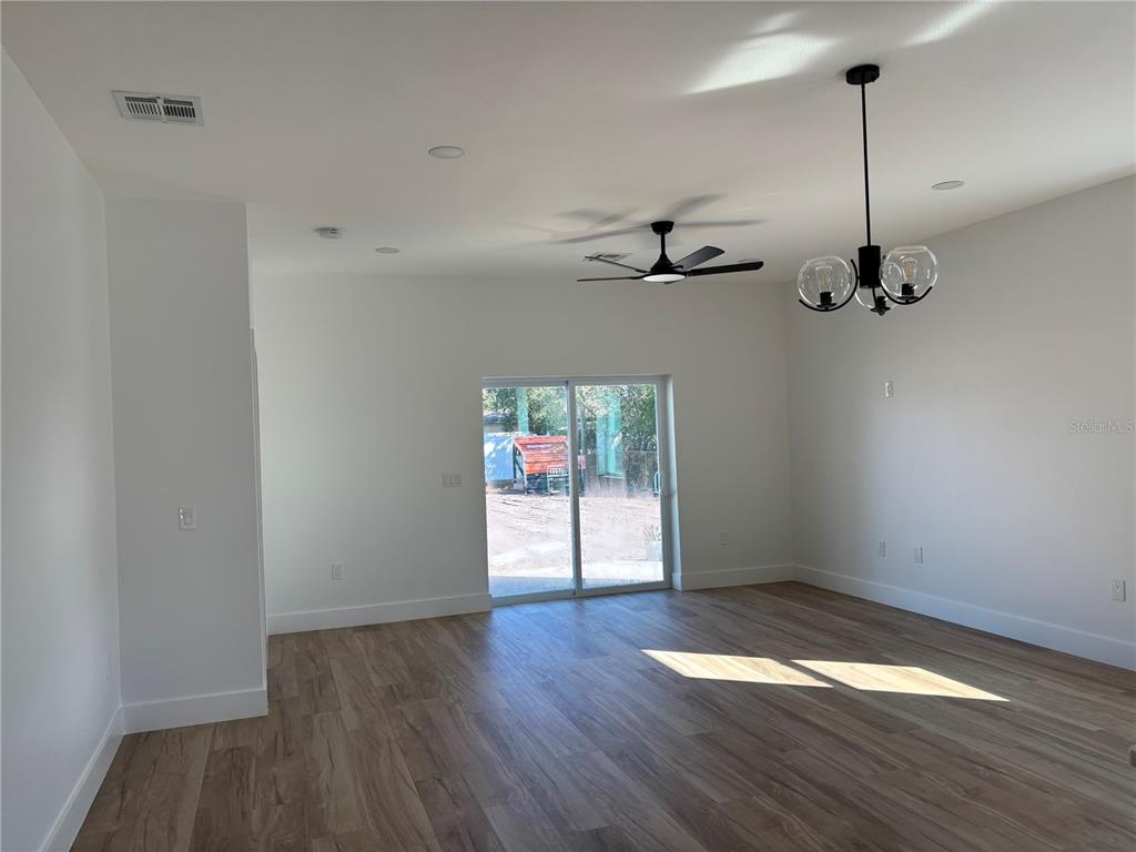 317 Quail Avenue Sebring, FL 33870 - Photo 4 of 19 a view of empty room with wooden floor and fan