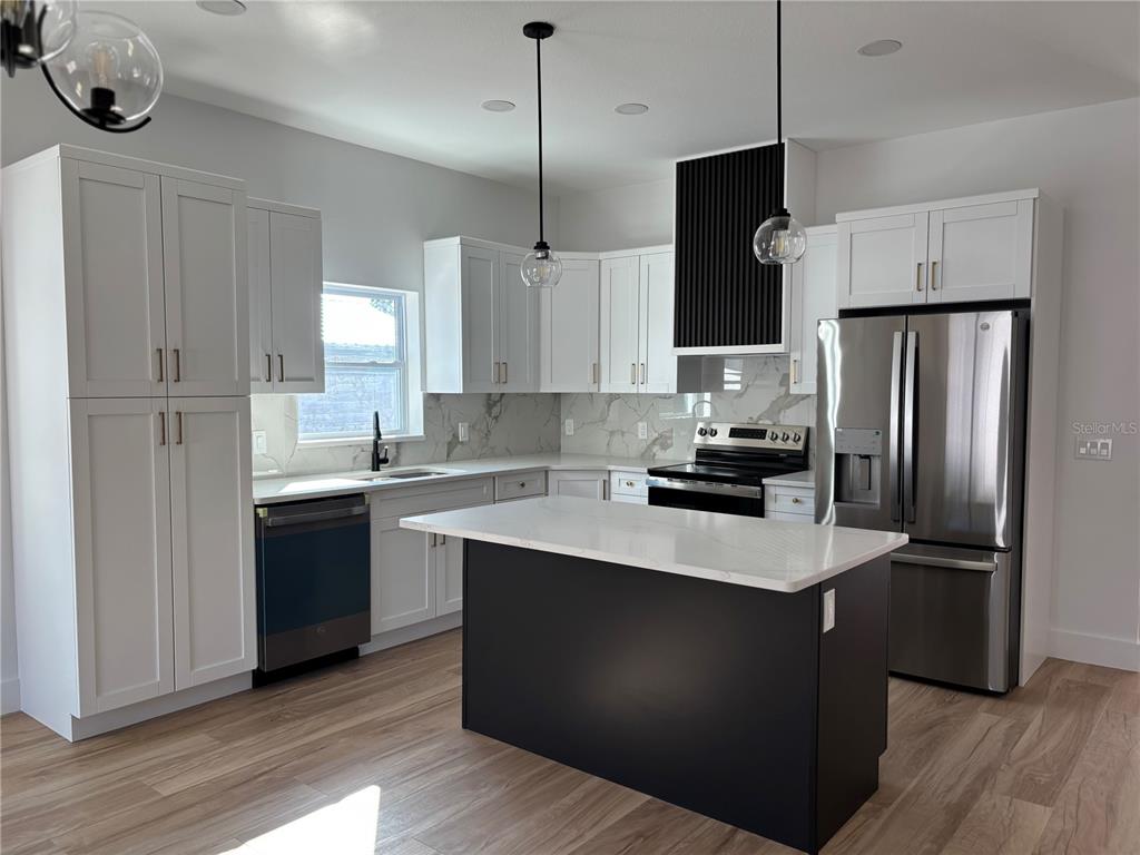 317 Quail Avenue Sebring, FL 33870 - Photo 5 of 19 a kitchen with kitchen island granite countertop a sink a counter space stainless steel appliances and cabinets