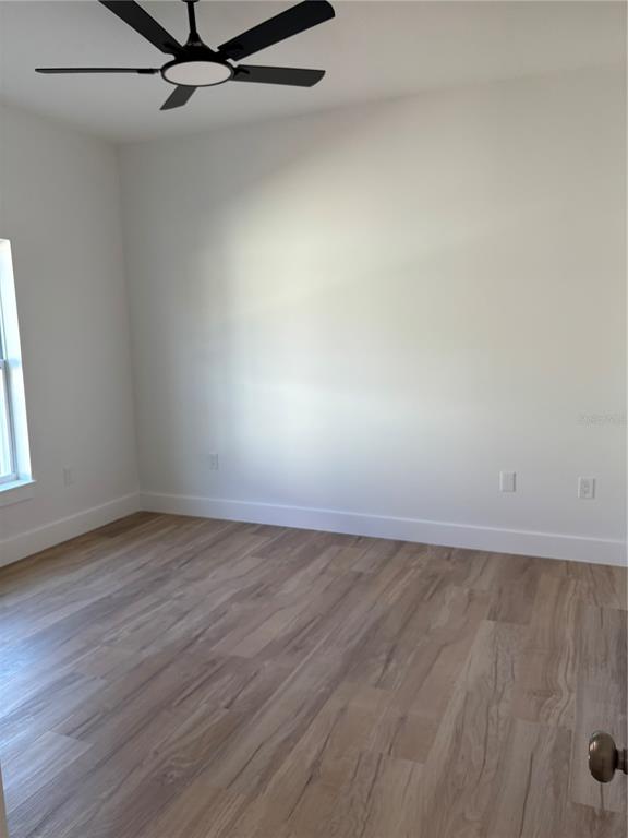 317 Quail Avenue Sebring, FL 33870 - Photo 8 of 19 an empty room with wooden floor and windows