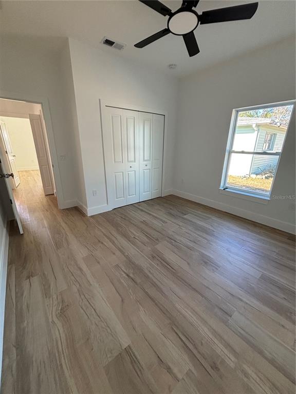 317 Quail Avenue Sebring, FL 33870 - Photo 9 of 19 an empty room with wooden floor fan and windows