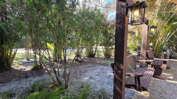 a view of a house with backyard and sitting area