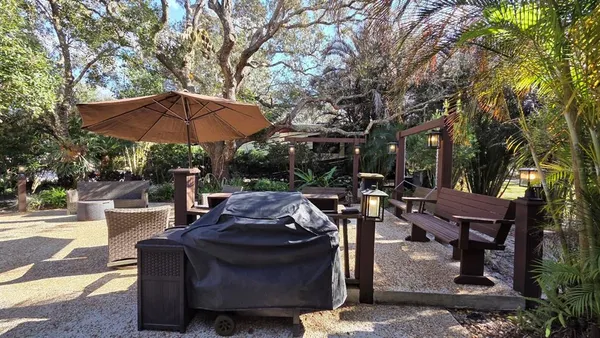 a view of a patio with table and chairs under an umbrella