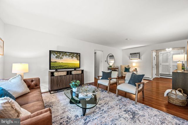 a living room with furniture a rug a window and a table