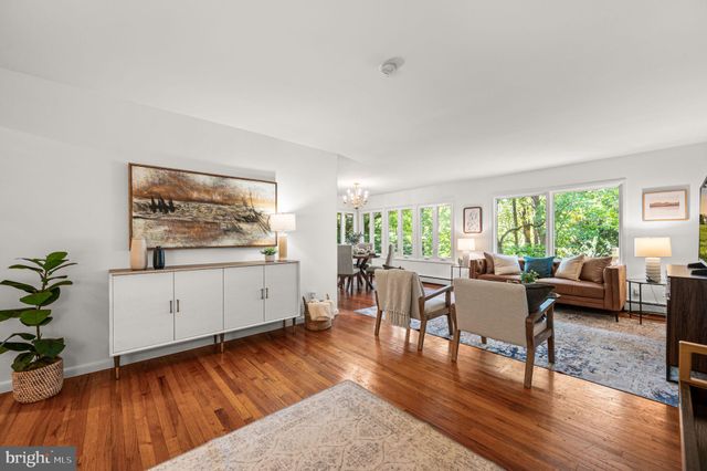a living room with furniture a wooden floor and next to a window