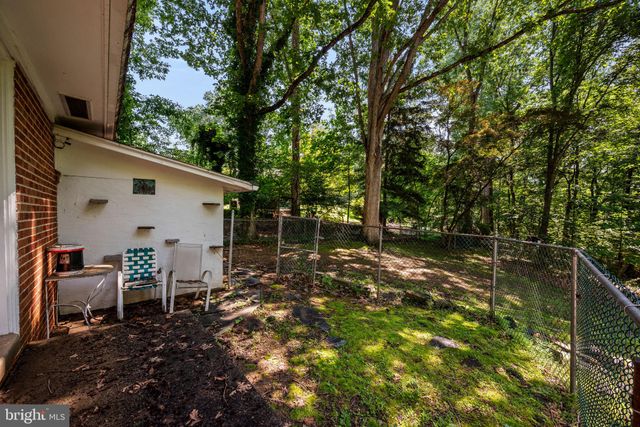 an aerial view of a house with a yard and trees all around
