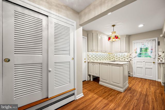 a kitchen with a sink cabinets and wooden floor