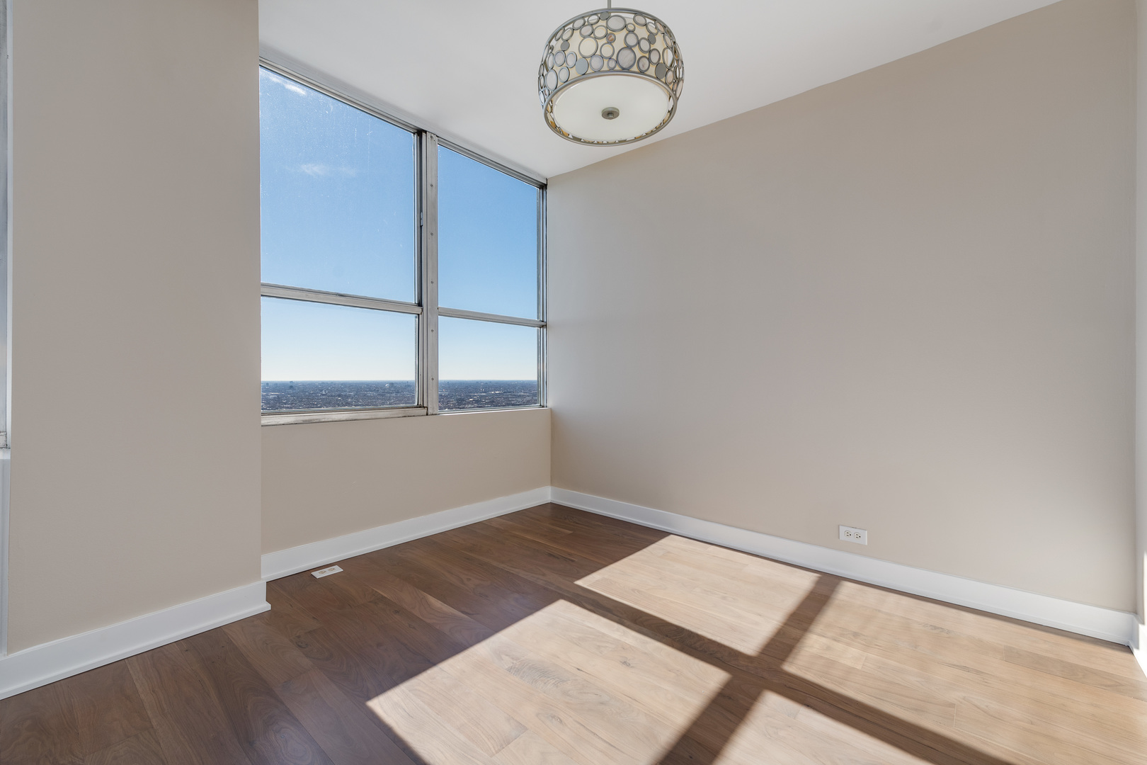655 West Irving Park Road, Unit 5103 Chicago, IL 60613 - Photo 13 of 30 an empty room with wooden floor and windows