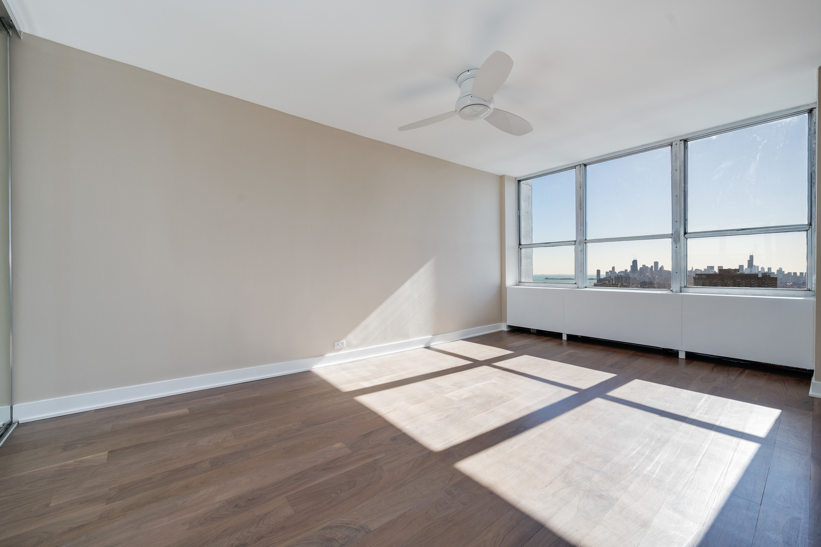 655 West Irving Park Road, Unit 5103 Chicago, IL 60613 - Photo 16 of 30 a view of an empty room with wooden floor and a window