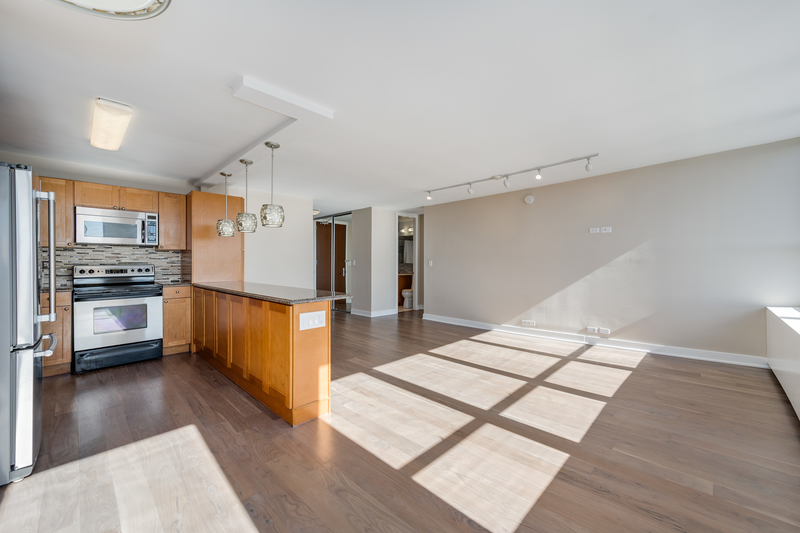 655 West Irving Park Road, Unit 5103 Chicago, IL 60613 - Photo 3 of 30 a kitchen with stainless steel appliances kitchen island granite countertop a refrigerator and a stove top oven