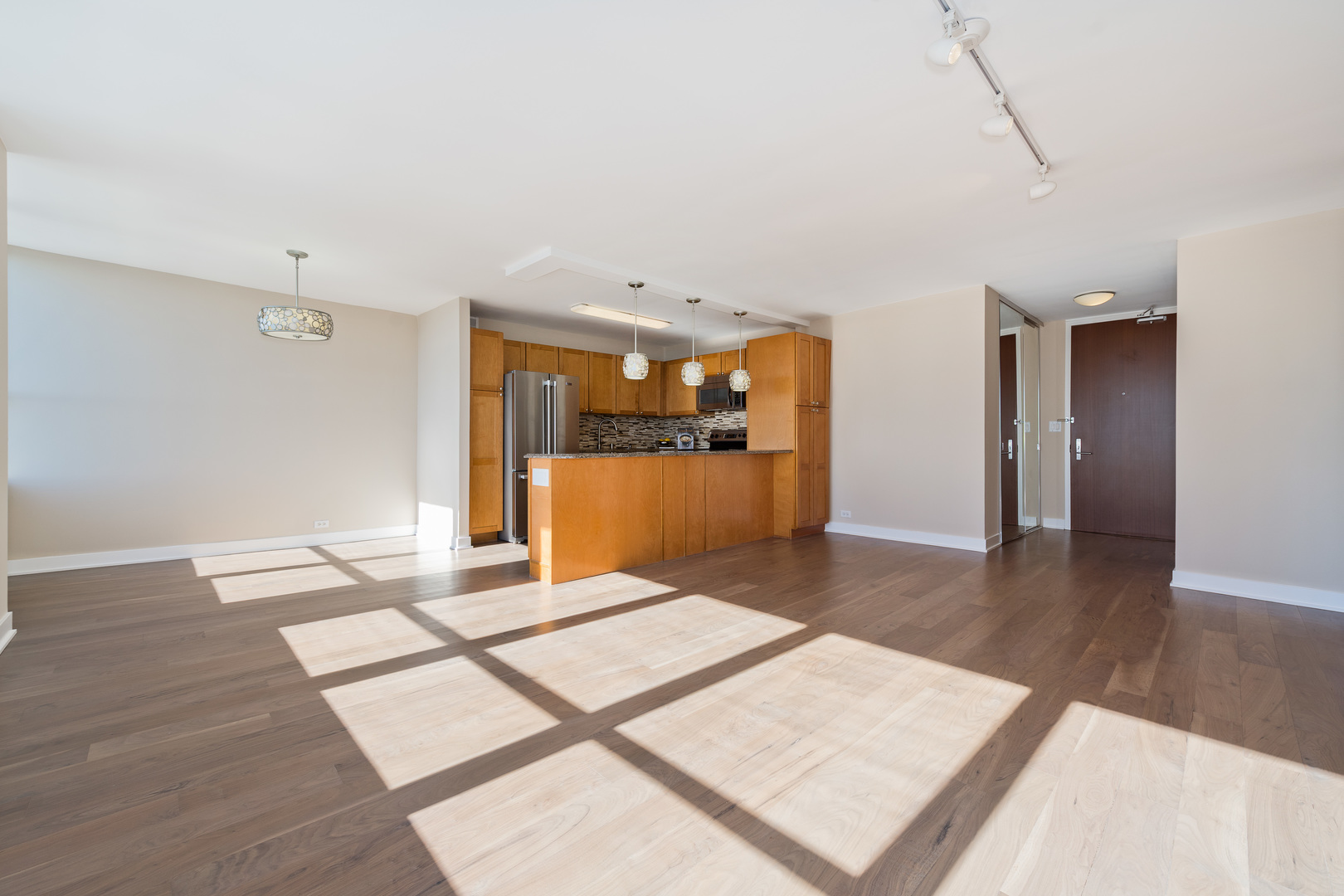 655 West Irving Park Road, Unit 5103 Chicago, IL 60613 - Photo 4 of 30 a view of a big room with wooden floor and a kitchen