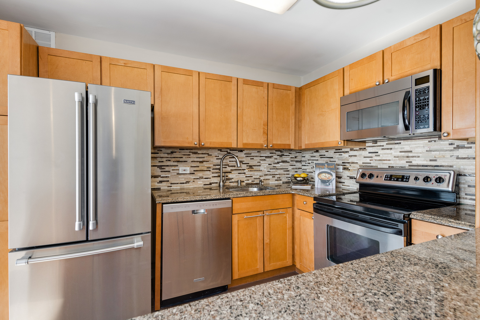 655 West Irving Park Road, Unit 5103 Chicago, IL 60613 - Photo 9 of 30 a kitchen with stainless steel appliances granite countertop a refrigerator stove top oven and sink