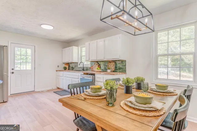 a kitchen with a table chairs a stove and cabinets