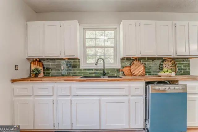 a kitchen with stainless steel appliances granite countertop a sink a stove and cabinets