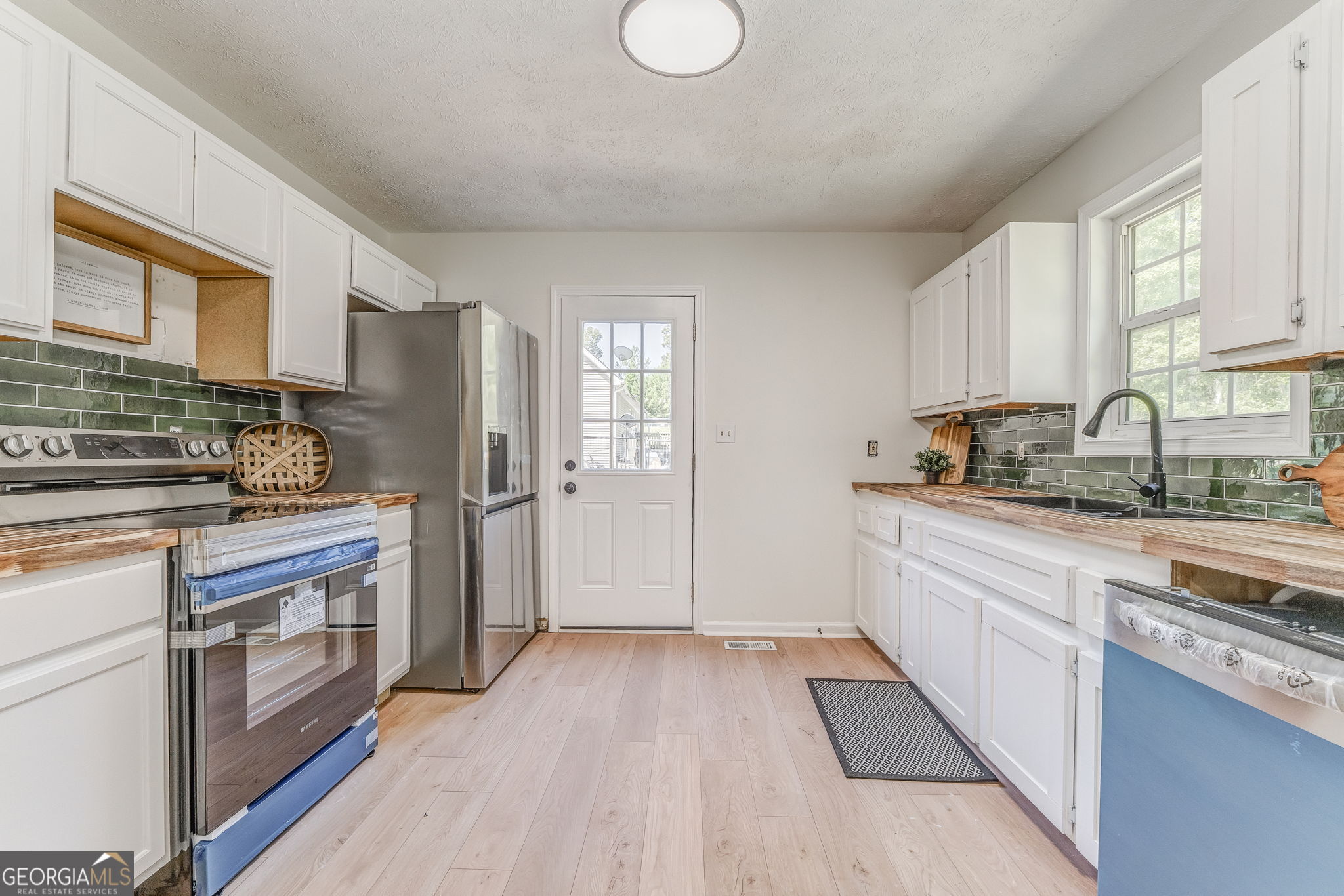 728 Hutto Road Cedartown, GA 30125 - Photo 19 of 40 a kitchen with granite countertop a refrigerator oven a sink dishwasher and white cabinets with wooden floor