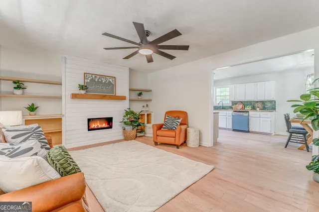 a living room with furniture and a kitchen area