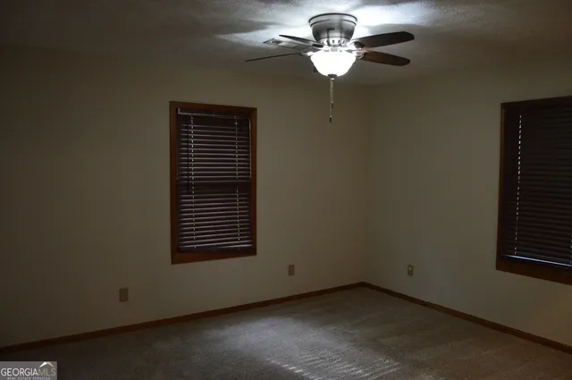 a view of a room with a ceiling fan and a window