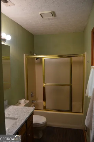 a bathroom with a granite countertop sink toilet and shower
