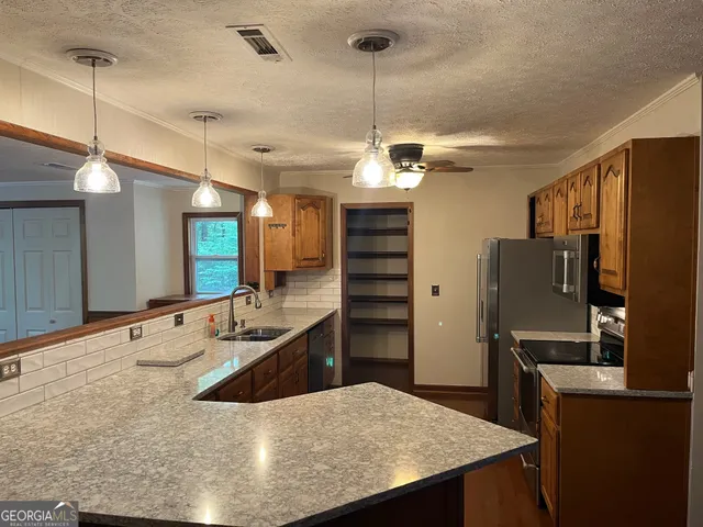 a large kitchen with kitchen island a counter space a sink and appliances