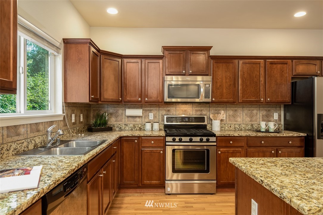 2719 232nd Street Southeast Bothell, WA 98021 - Photo 11 of 24 a kitchen with kitchen island granite countertop a sink stove and oven