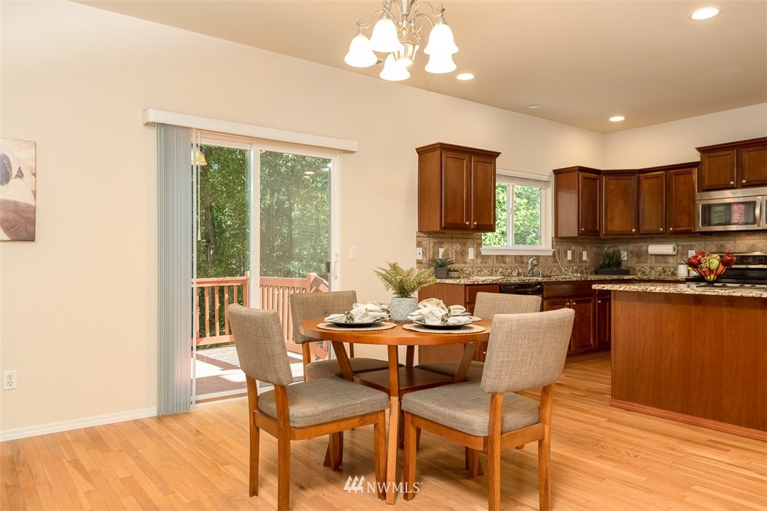2719 232nd Street Southeast Bothell, WA 98021 - Photo 8 of 24 a dining room with wooden floor and a chandelier
