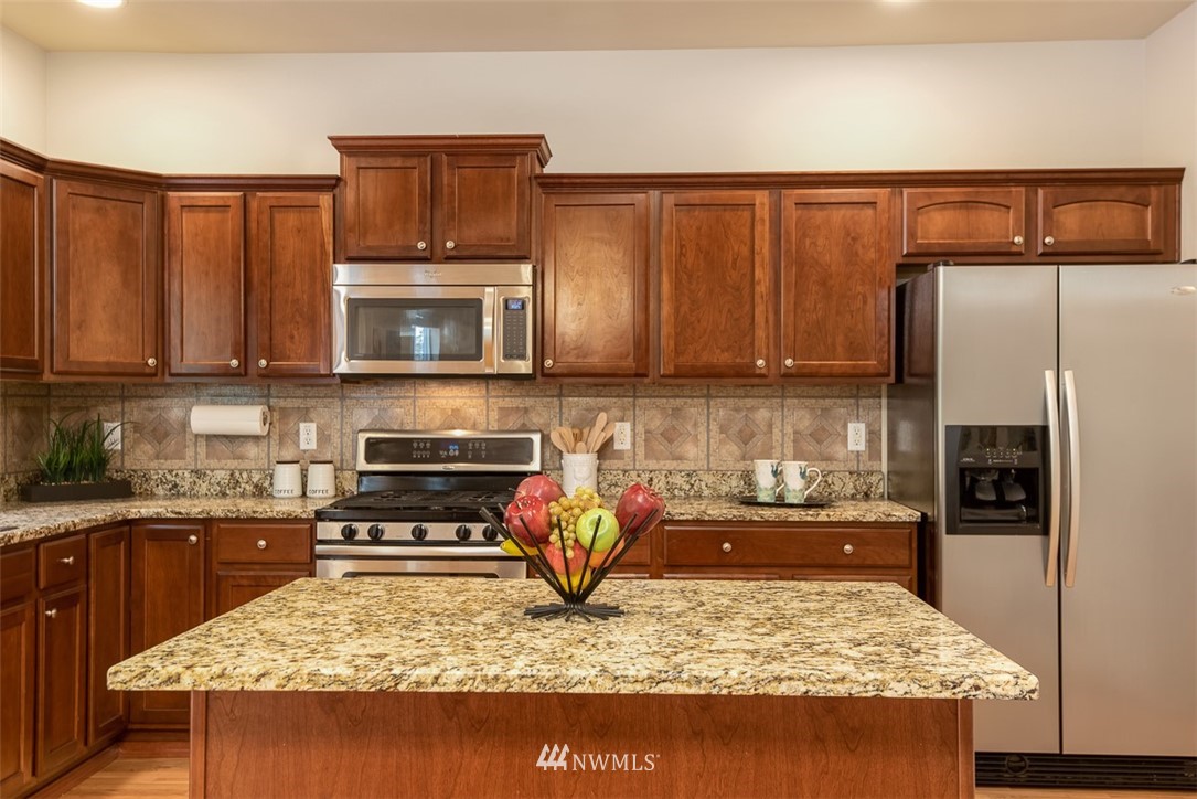 2719 232nd Street Southeast Bothell, WA 98021 - Photo 10 of 24 a kitchen with a refrigerator and a stove top oven
