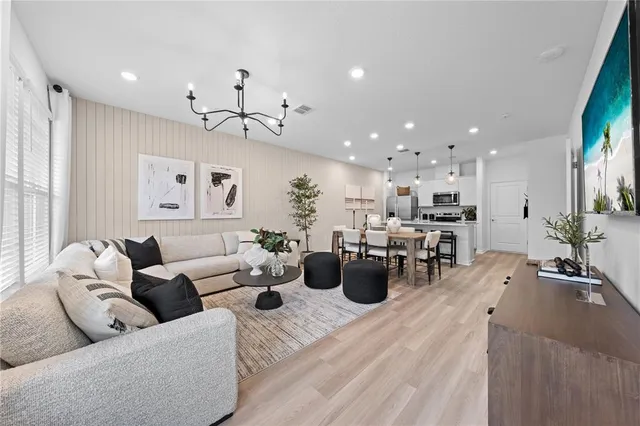 a living room with furniture kitchen view and a large window