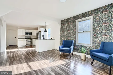 a living room with furniture and a kitchen view