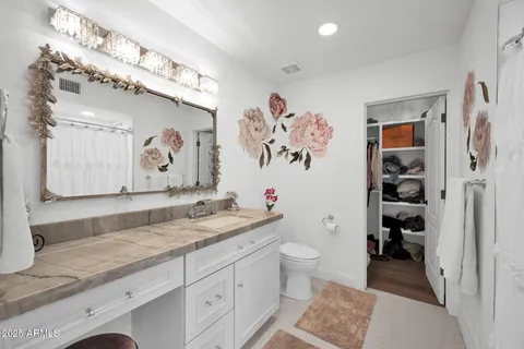 a bathroom with a granite countertop sink mirror vanity and toilet