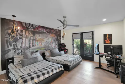 a bedroom with a bed couch and a flat tv screen next to a window