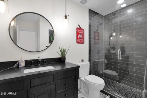 a bathroom with a toilet a sink and mirror