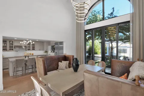 a living room with furniture a large window and wooden floor