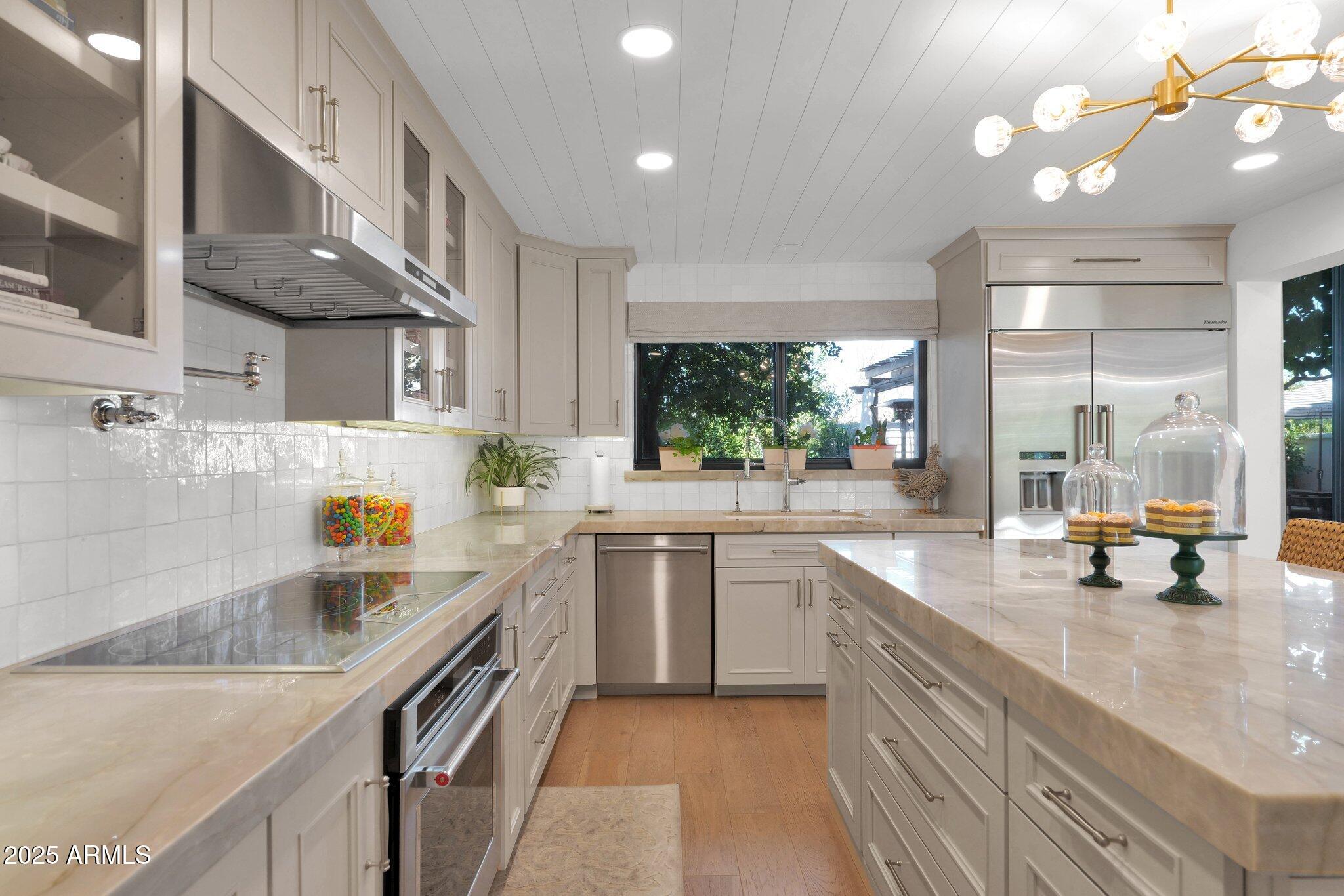 6701 North Scottsdale Road, Unit 24 Scottsdale, AZ 85250 - Photo 7 of 37 a kitchen with stainless steel appliances a sink a stove and a wooden floors