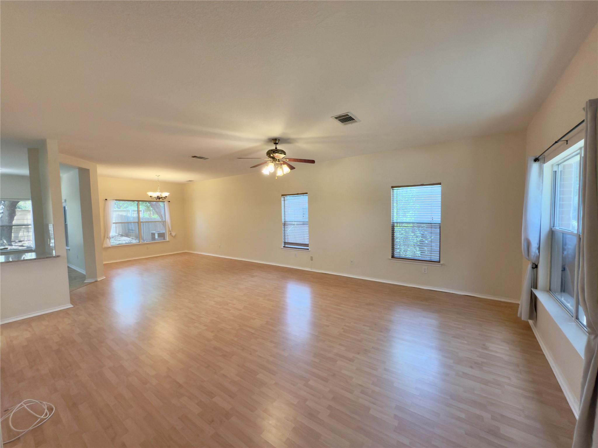 1206 Devil Ridge Cedar Park, TX 78613 - Photo 14 of 38 an empty room with wooden floor chandelier and windows