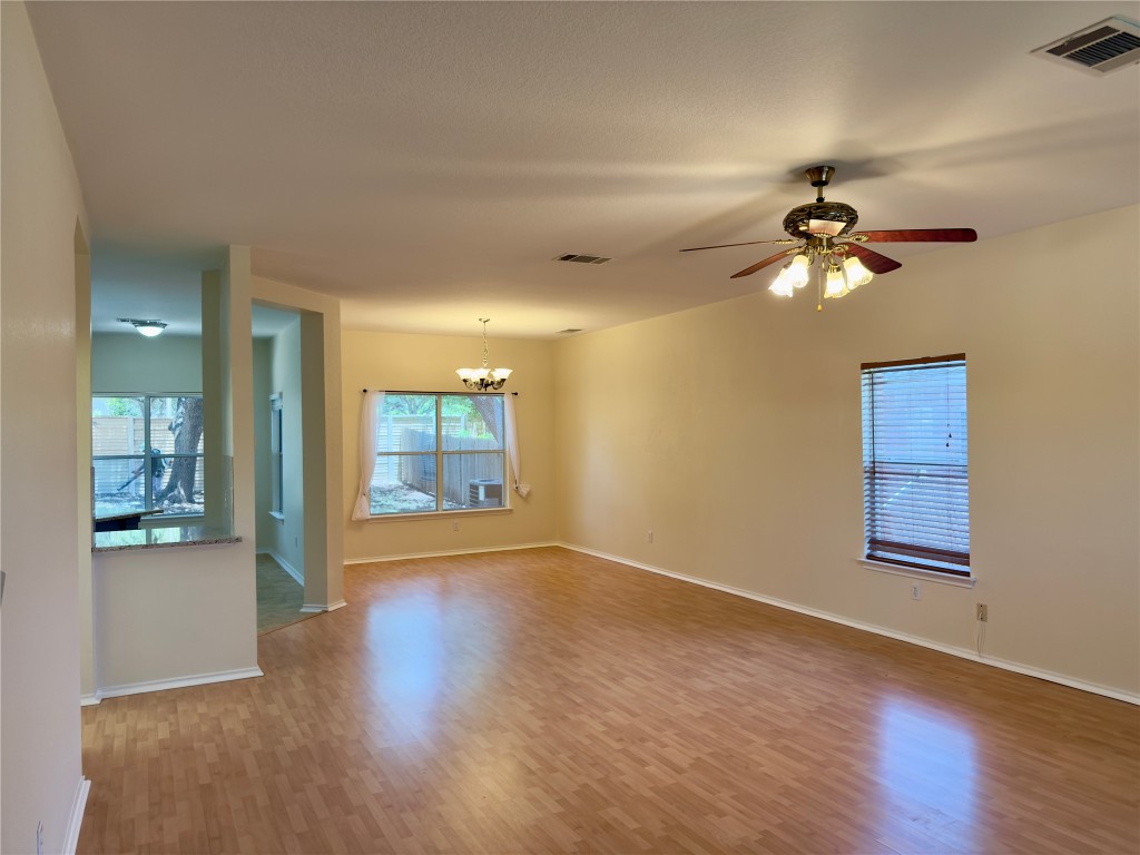 1206 Devil Ridge Cedar Park, TX 78613 - Photo 16 of 38 Spare room featuring a chandelier, wood finished floors, healthy amount of natural light, and ceiling fan
